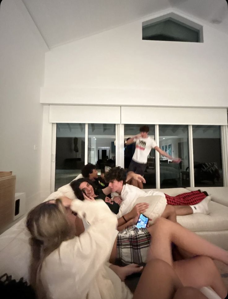 a group of people sitting on top of a white couch