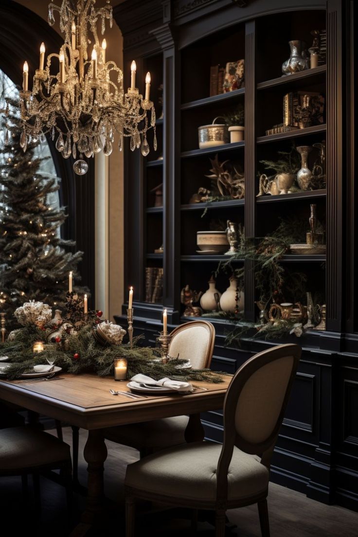 a dining room table set for christmas with candles and decorations on the table, surrounded by bookshelves