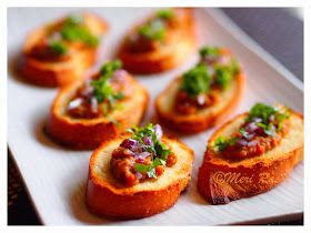 small breads with meat and vegetables on them sitting on a white plate, ready to be eaten