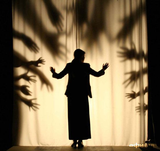 a woman standing in front of a curtain with her hands out