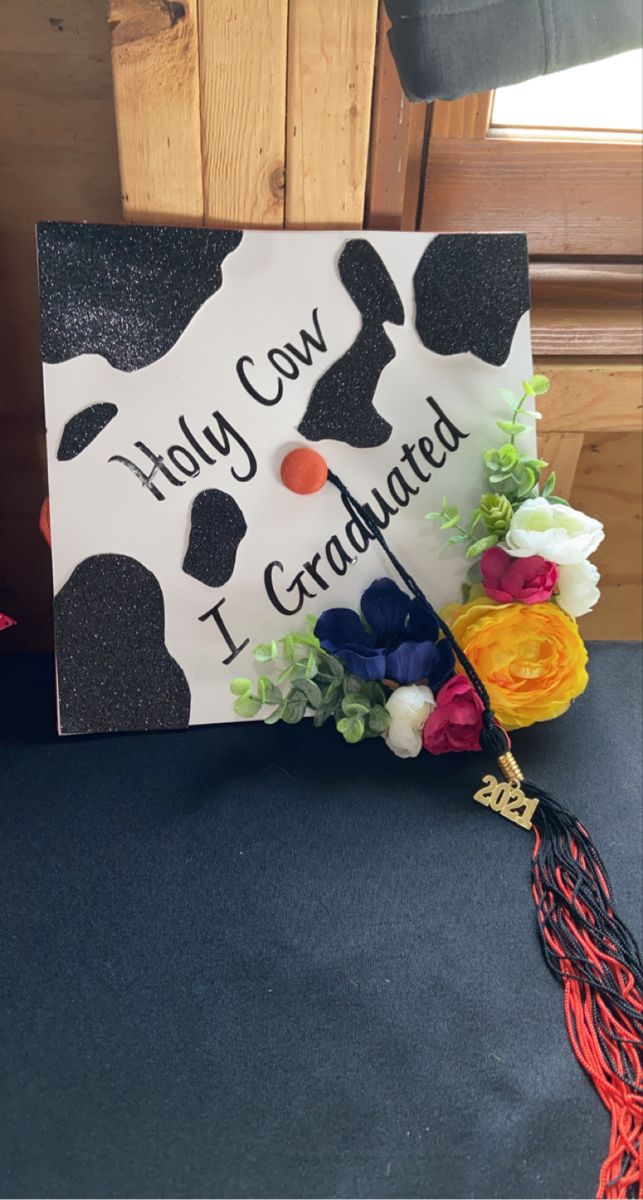 a graduation cap that has been decorated with flowers and the words, holly cow i graduated