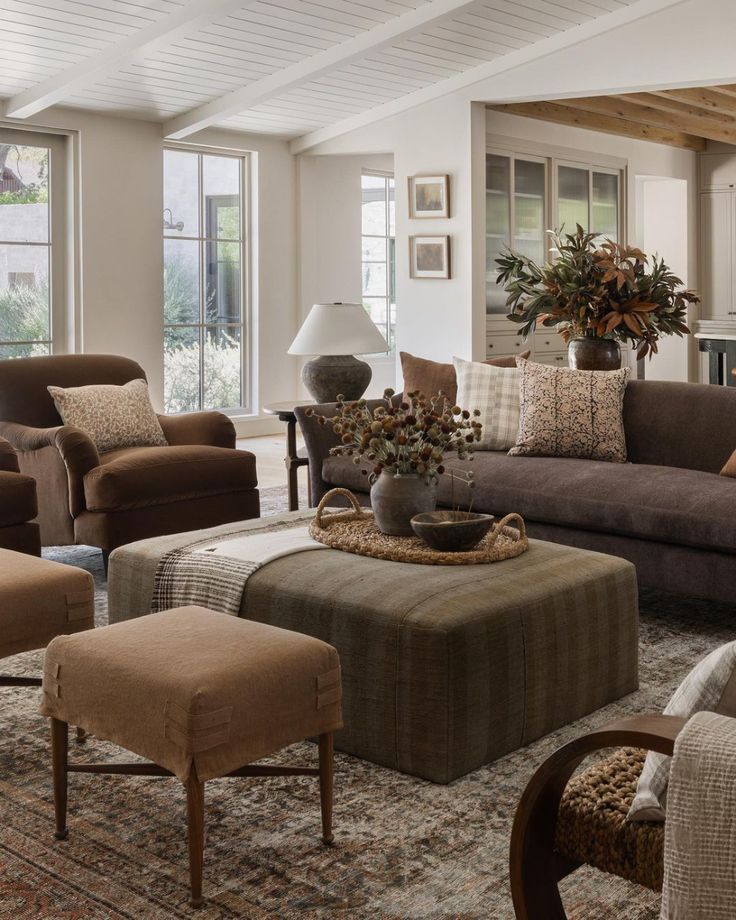 a living room filled with lots of furniture and decor on top of a carpeted floor