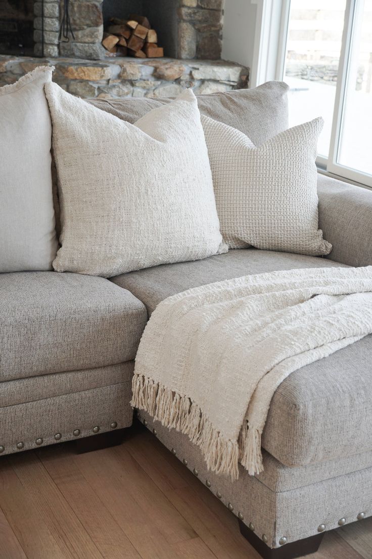 a living room with a couch, pillows and a fire place