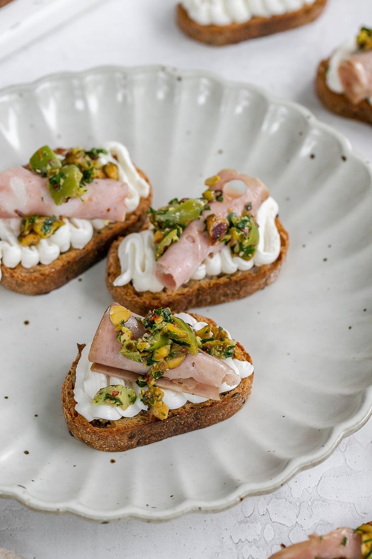 small pieces of bread with meat and vegetables on them