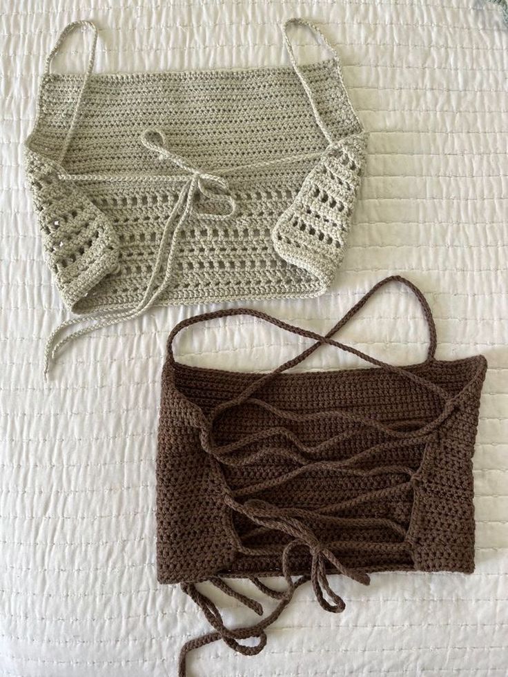 two crocheted purses sitting on top of a white bed next to each other