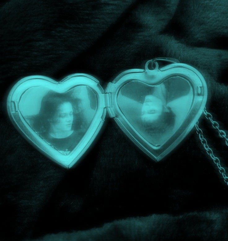 two heart shaped lockes with a woman's face in the reflection on them