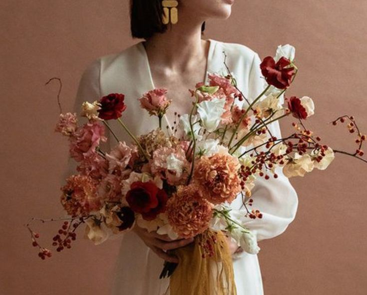 a woman holding a bouquet of flowers in her hands