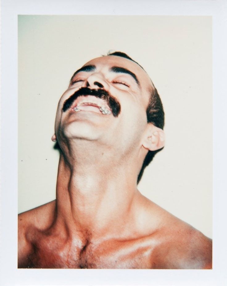 a man with no shirt and mustache looking up