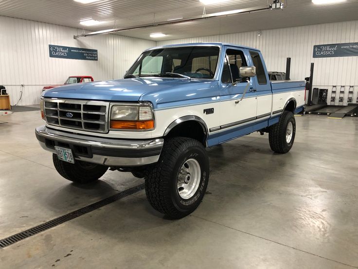 a blue and white truck parked in a garage