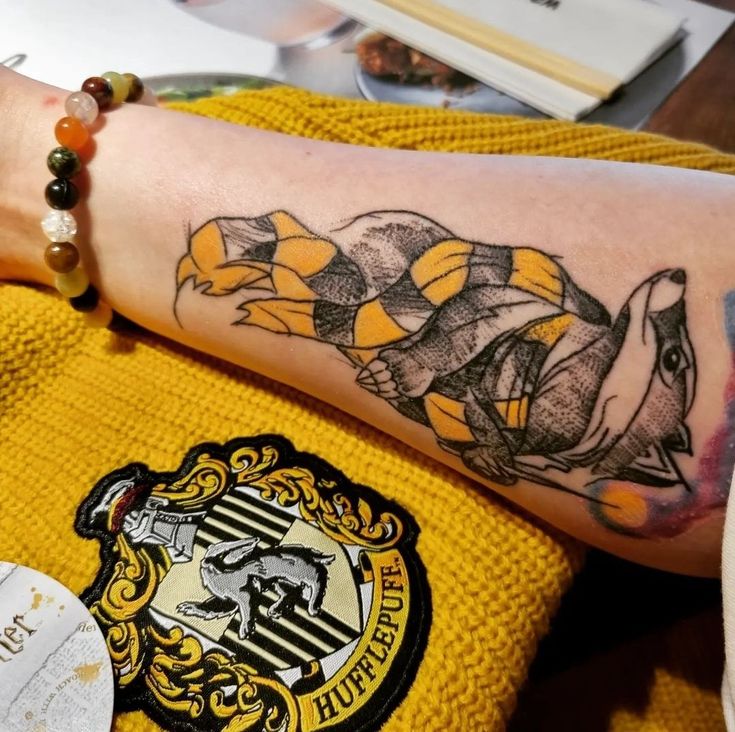 a harry potter tattoo with hogwarts on it's arm and the hogwarts crest