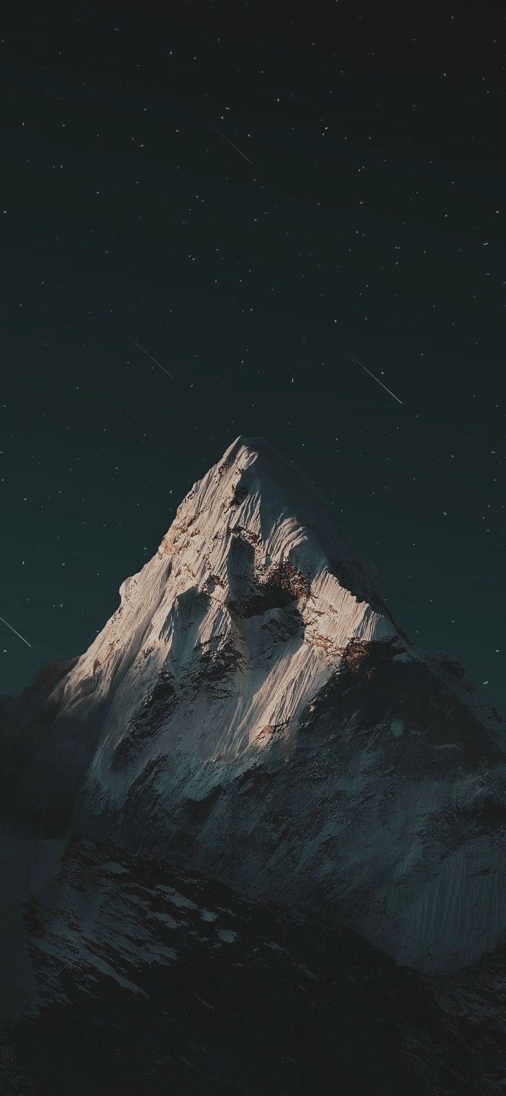 the top of a snow covered mountain under a night sky