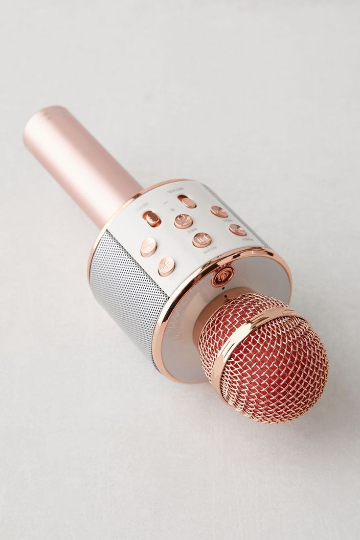 an old fashioned microphone on a white surface with red and silver knobs in the middle