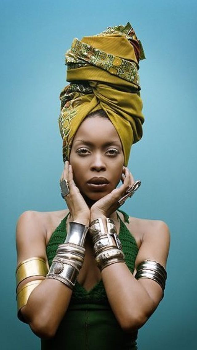 an african woman with gold accessories on her head and hands in front of her face