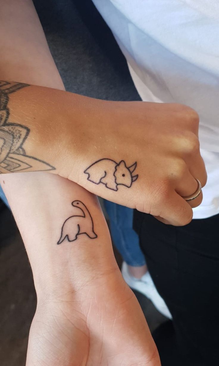 two people with matching tattoos on their arms