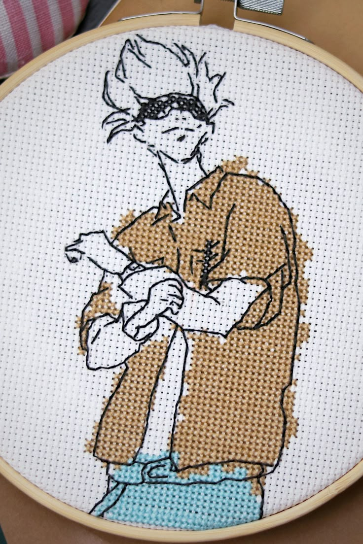 a cross stitched picture of a man holding a baseball bat in his right hand