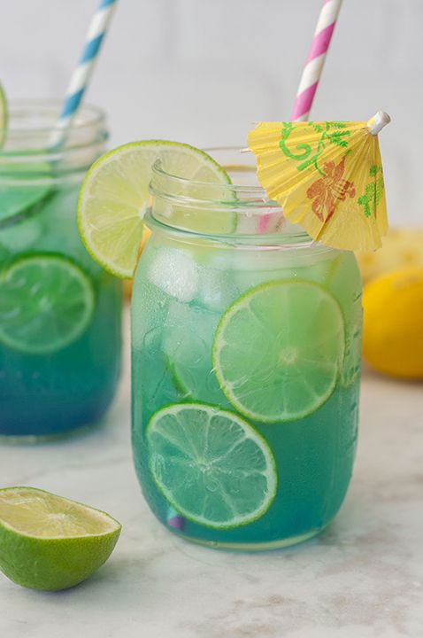 two mason jars filled with lemonade and limes