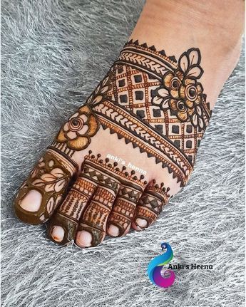 a henna tattoo on the foot of a woman's hand with intricate designs