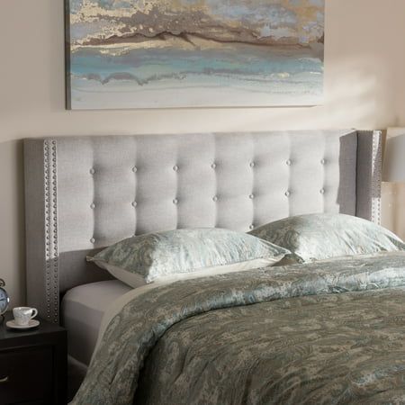 a bedroom with a bed, night stand and painting on the wall above it's headboard