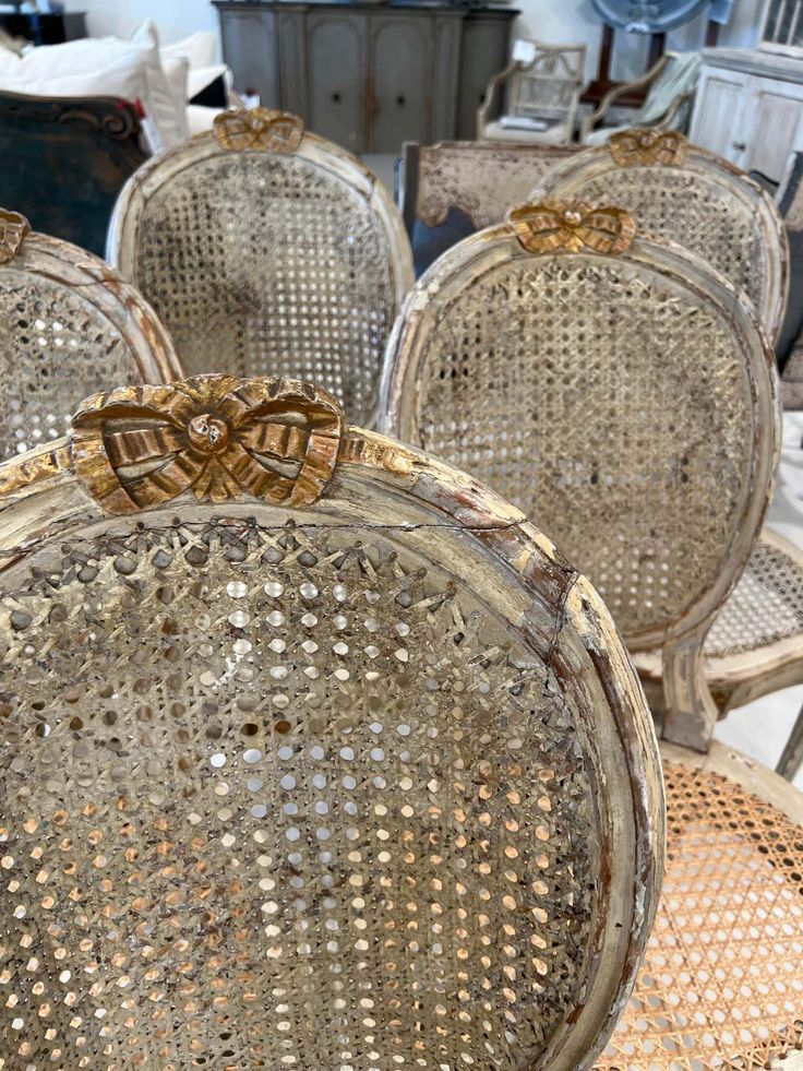 four antique chairs with bows on them are sitting in a room filled with other furniture