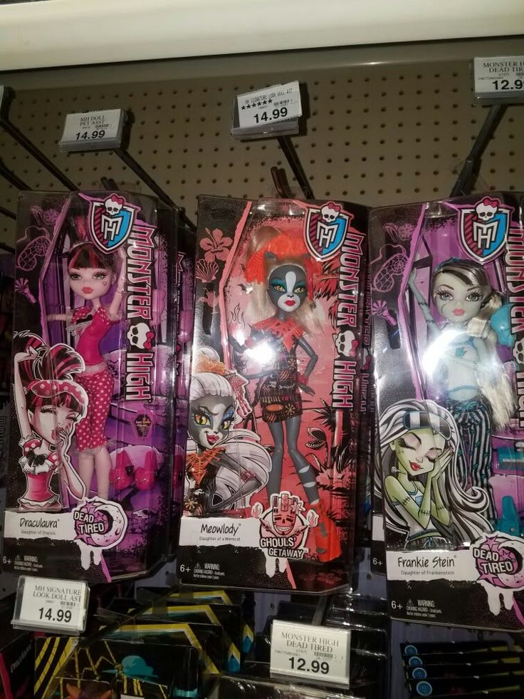 several monster high dolls are on display for sale in a toy store, one is pink and the other is black