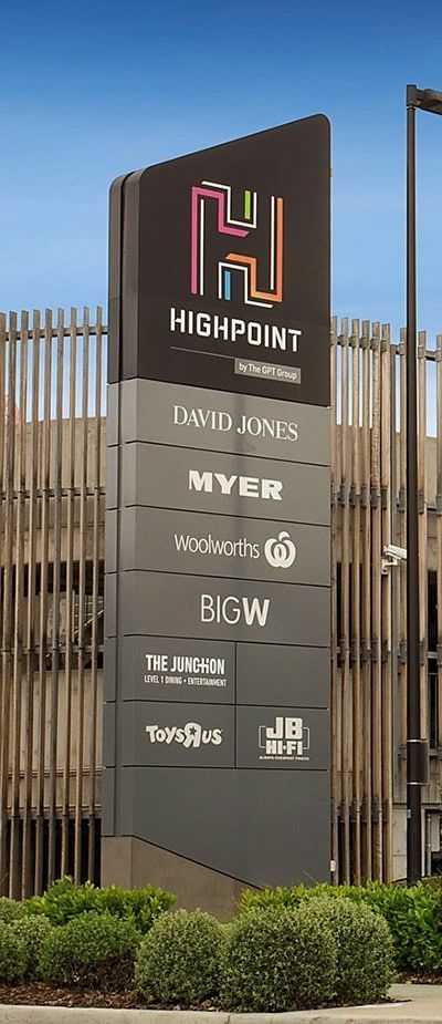 the sign for highpoint is in front of a building with wooden fence and bushes