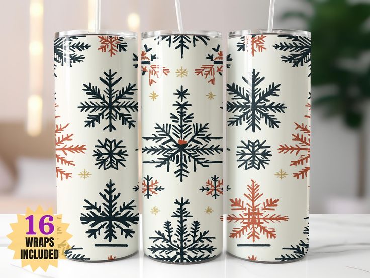 three white christmas candles with red and black snowflakes on them, sitting on a table