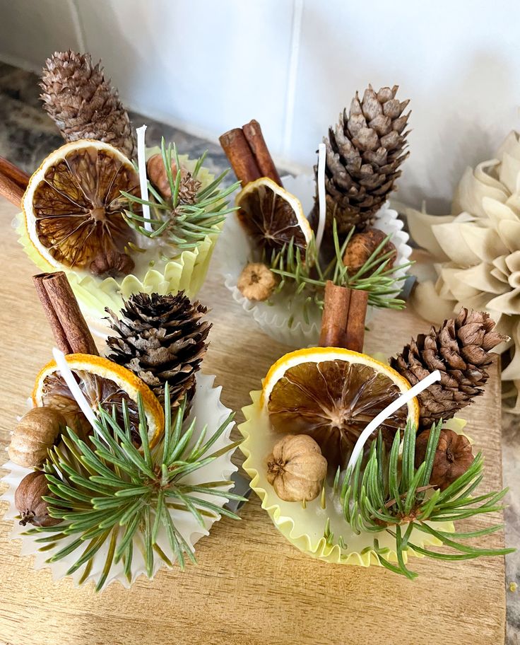 pine cones, orange slices and cinnamon sticks are arranged on a table