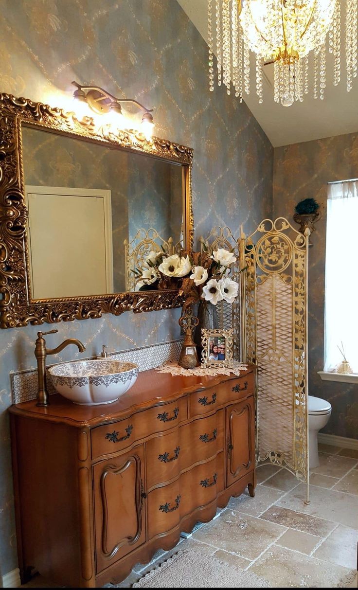 a bathroom with a vanity, mirror and chandelier