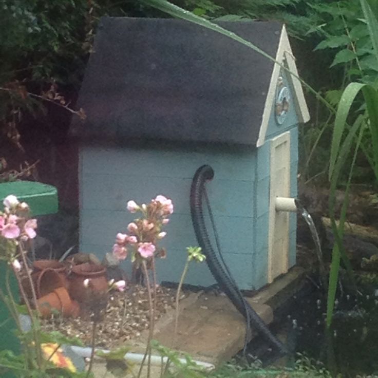 there is a small blue house with a hose attached to it