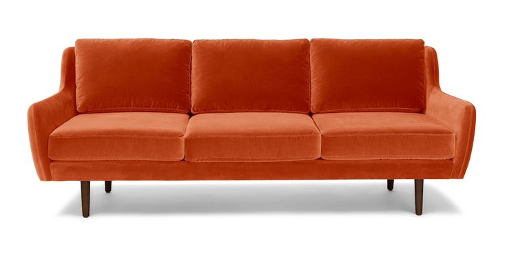 an orange couch sitting on top of a white floor