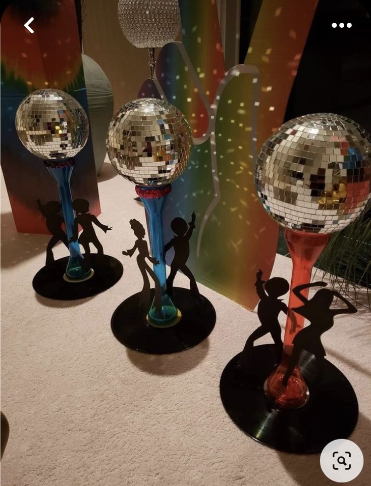 three disco balls are on display in front of a mirror