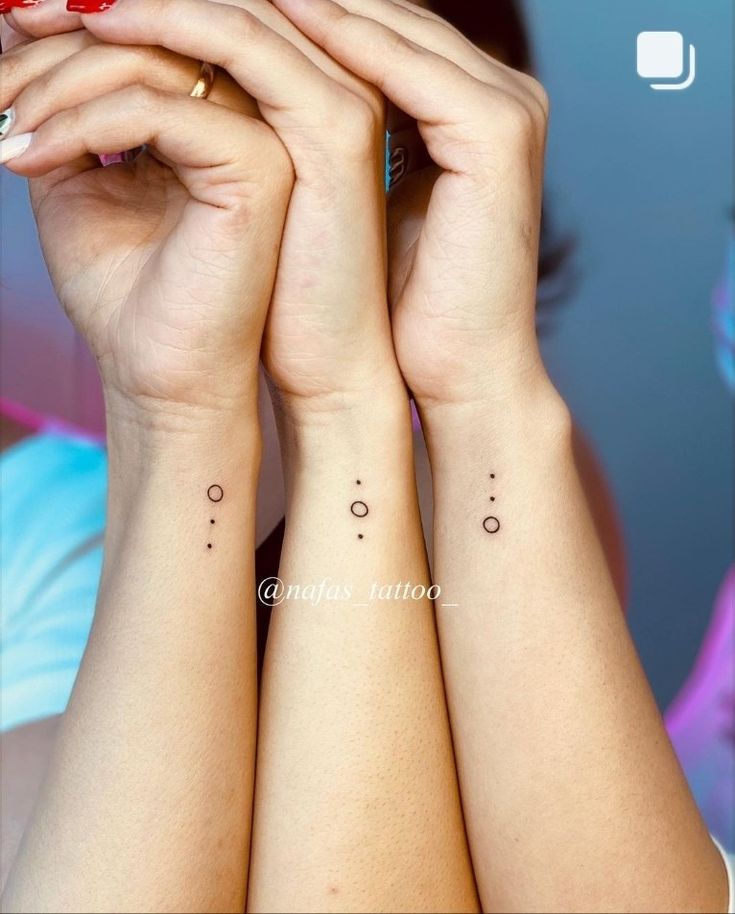 two women with matching tattoos on their arms