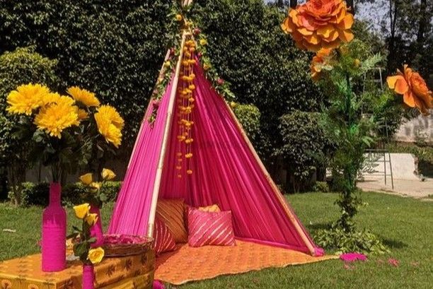 a pink and yellow teepee with flowers on it