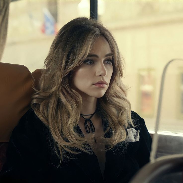 a woman sitting on a bus looking off into the distance