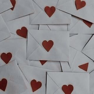 many envelopes with red hearts on them are scattered around each other in an arrangement