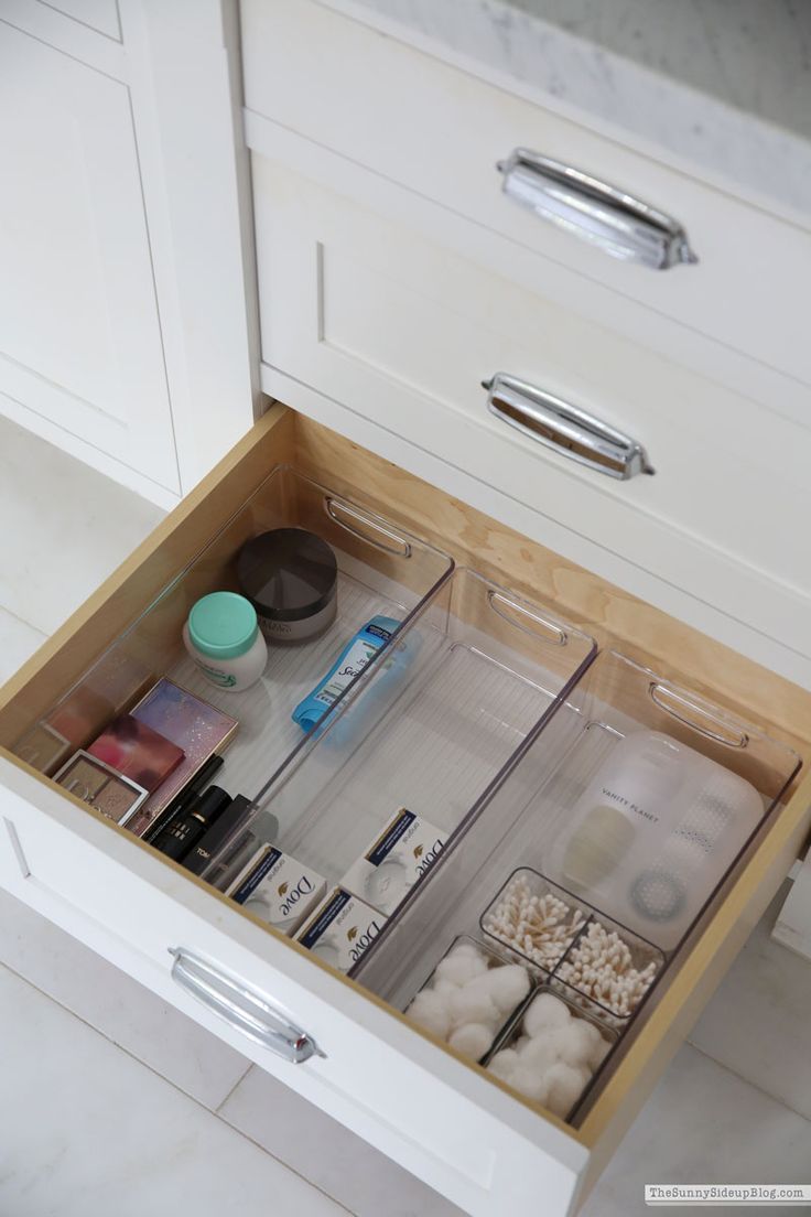 an open drawer in a kitchen filled with cosmetics