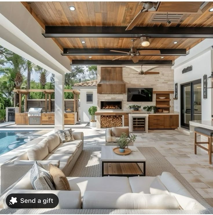 a living room with couches, tables and an outdoor kitchen next to a swimming pool