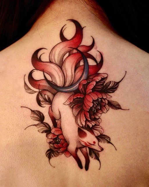 the back of a woman's neck with flowers and leaves on it, as well as an abstract tattoo design