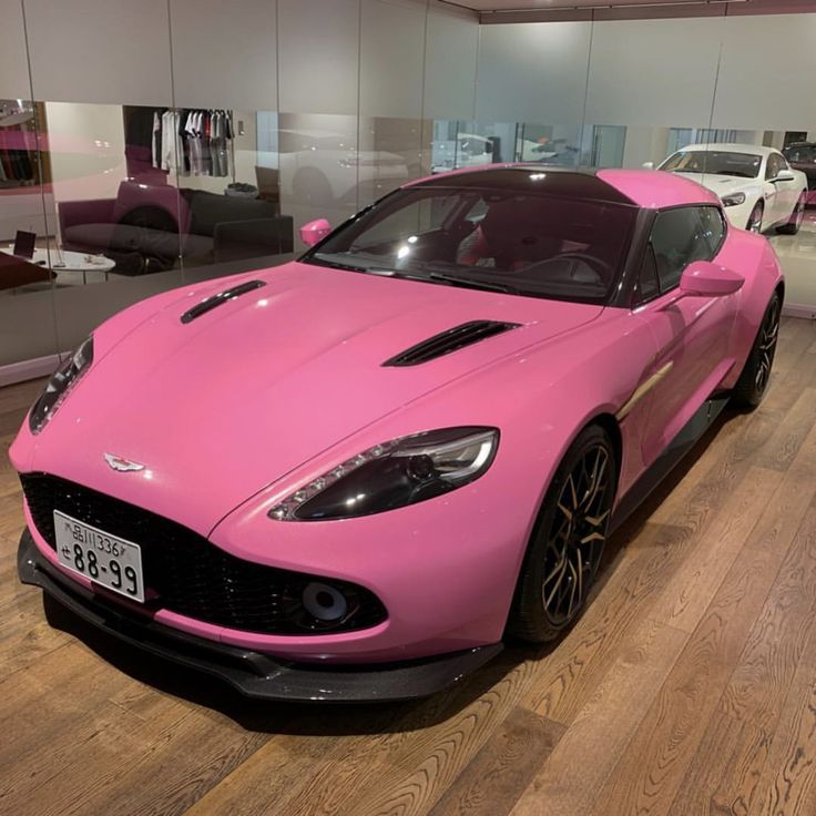 a pink sports car is on display in a showroom