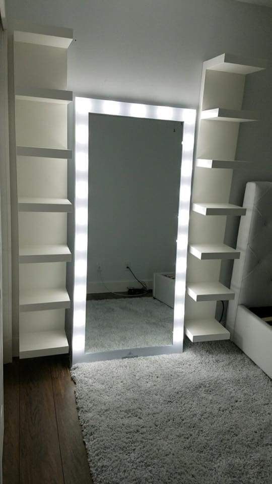 an empty room with white shelving and lights on the wall, carpeted floor