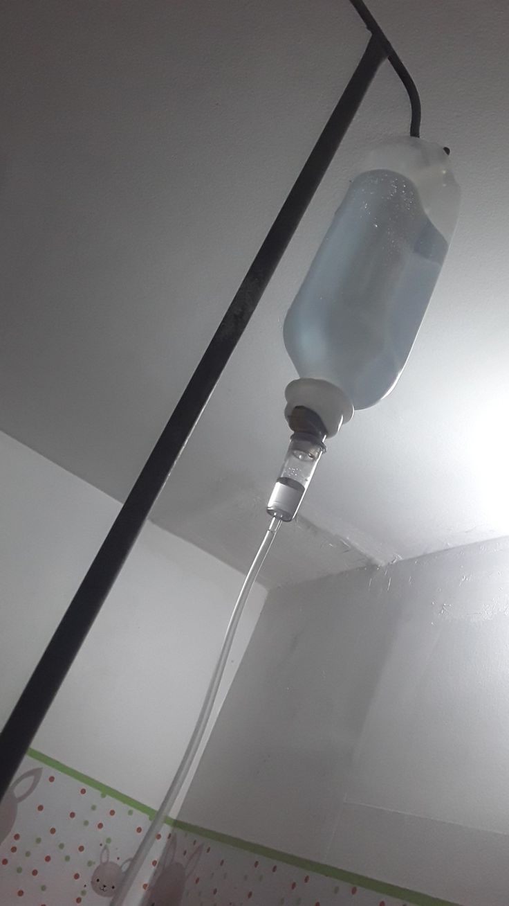 a water bottle hanging from the ceiling in a room with white walls and polka dot wallpaper