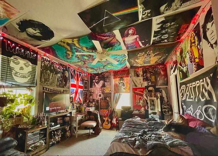 a room filled with lots of posters and pictures on the walls, including a guitar