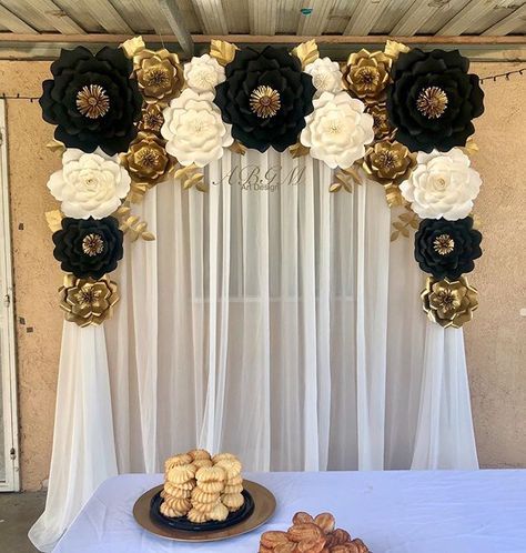 a table topped with pastries and flowers next to a white curtain