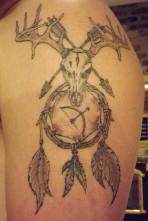 the back of a woman's thigh with an arrow and deer head on it