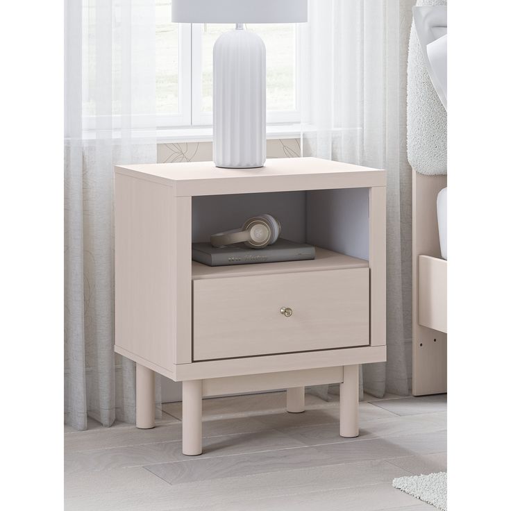 a night stand with two drawers and a white lamp on the end table next to it