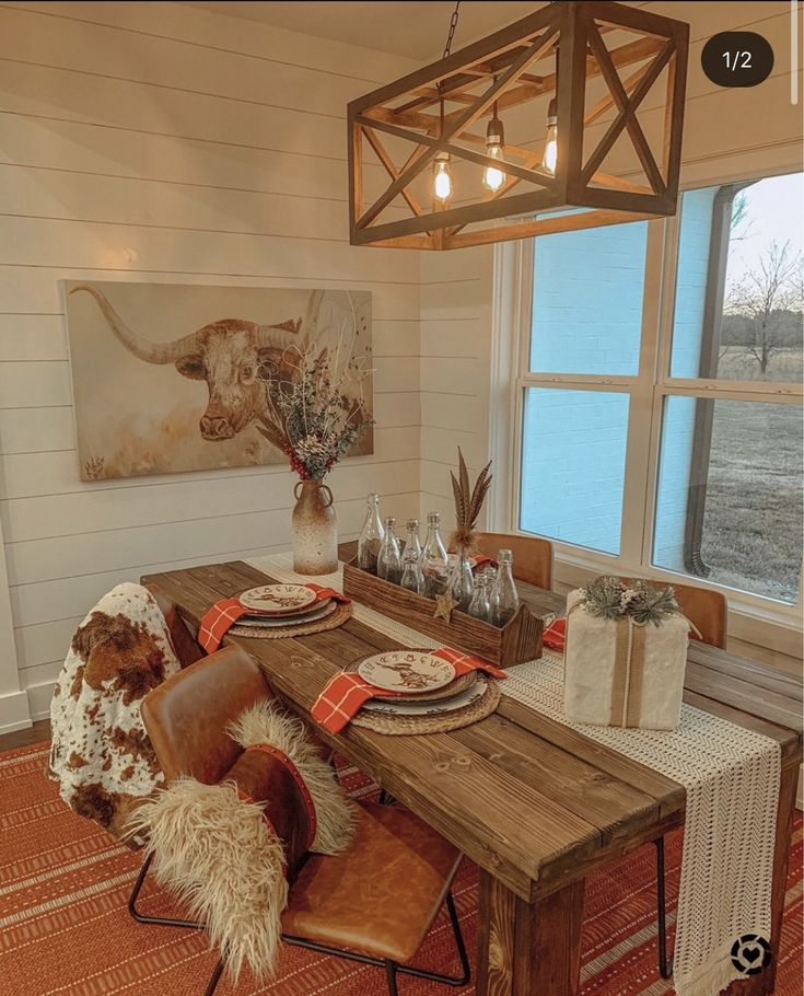 the dining room table is set with place settings for two people, and there's a cow head hanging from the ceiling