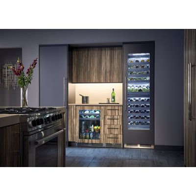 a kitchen with an oven, refrigerator and wine rack in the corner next to it