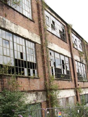 an old brick building with broken windows and vines growing on the side of it's sides