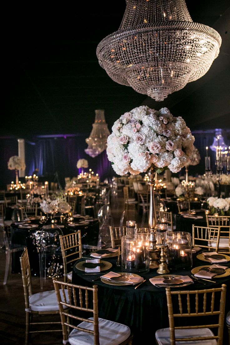 the tables are set up with black linens and white flowers in centerpieces