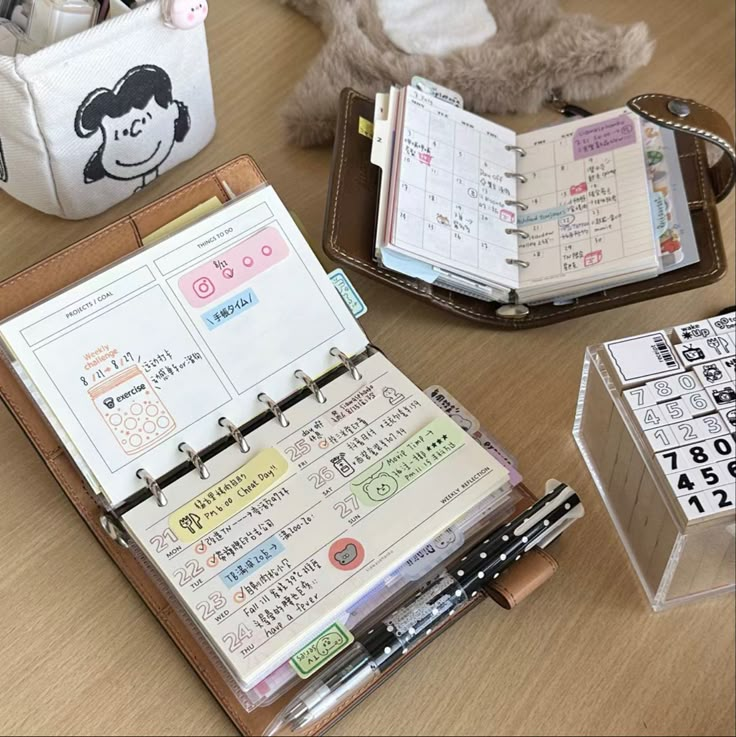 an open planner book sitting on top of a wooden table next to a stuffed animal